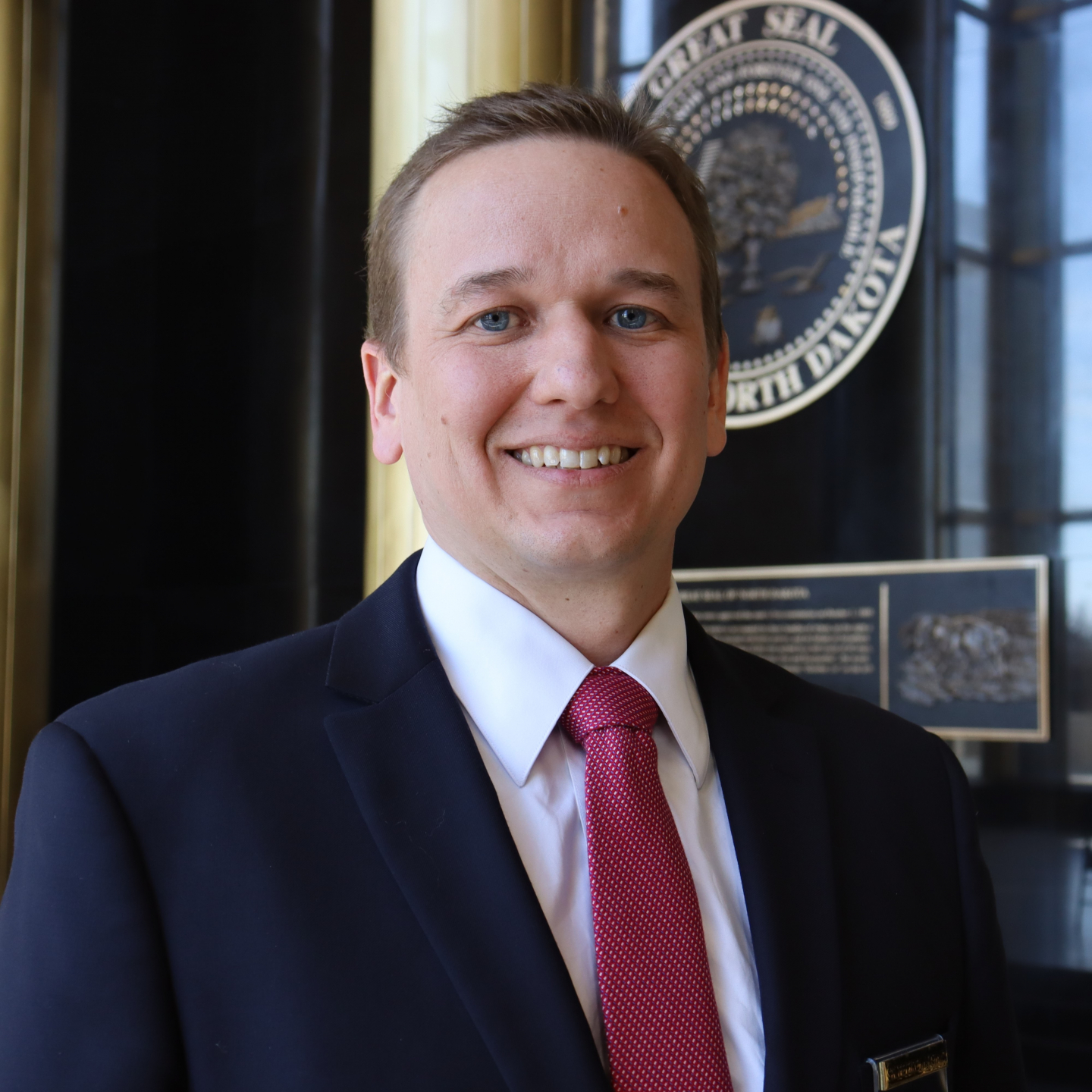 A man in a suit smiling.