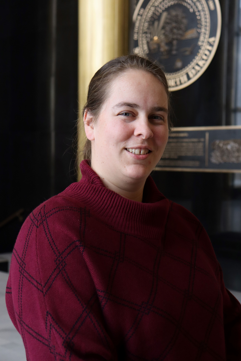 A woman standing and smiling at the camera.